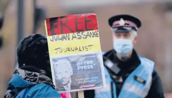  ?? KIRSTY WIGGLESWOR­TH/AP ?? With just over a week left in his term, President Donald Trump has not granted a pardon to WikiLeaks founder Julian Assange. Above, a supporter of Assange holds a placard Jan. 4 outside the Old Bailey court building in London.