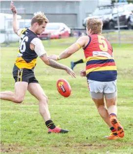  ??  ?? Left: Troy McPherson gets his kick away for Lang Lang as Longwarry’s Aaron Serong attempts to spoil the kick.