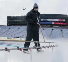  ?? Eliot J. Schechter/nhli via Afp/getty Images ?? A member of the ice crew floods the ice at Michigan Stadium in Ann Arbor leading up to the New Year’s Day Winter Classic.