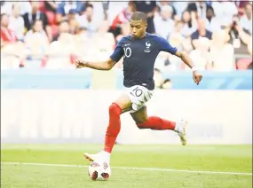  ?? Franck Fife / AFP/Getty Images ?? Kylian Mbappe scores France’s fourth goal, his second of the day, in Saturday’s match against Argentina.