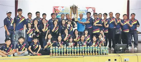  ??  ?? Clement Chen (ninth right) lifts the Tan Thian Kee challenge trophy as the Sibu contingent celebrate their victory in the 57th Sarawak Table Tennis Championsh­ip at the Serian Community Hall on Saturday.