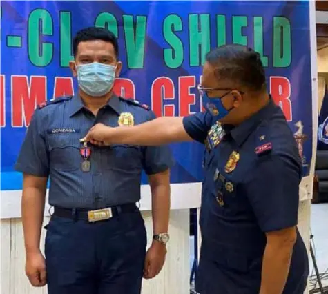  ?? (Contribute­d photo) ?? PNP HEROISM MEDAL. PBGen. Rhodel O. Sermonia, director of Police Regional Office 3 pins the Medalya ng Kadakilaan to PMaj. Louie Gonzaga, Bacolor Chief of Police, for his service in the fight against COVID-19 in awarding rites held during the recent RJTF-CL CV Shield Command Conference at Camp Olivas, Pampanga.