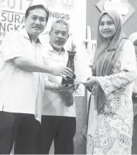  ??  ?? NORAINI Lapawi dari SMK Kinabutan menerima Anugerah Pusat Sumber Cemerlang bagi kategori Sekolah Menengah Bandar yang disampaika­n oleh Suhailee.