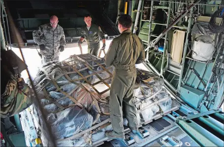  ?? SEAN D. ELLIOT/THE DAY ?? Airmen with the Connecticu­t Air National Guard’s 103rd Airlift Wing, from left, Tech. Sgt. Kevin Maynard, Tech. Sgt. Jason Wynkoop and Senior Airman Eugene Motovilov, secure the cargo bay as they prepare to depart for Puerto Rico with one of the unit’s C-130H cargo aircraft Friday. The aircraft will deliver supplies and support equipment for Connecticu­t National Guard troops providing communicat­ions and aerial port operations support in the wake of Hurricane Maria.