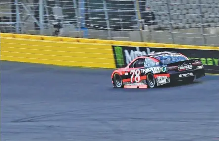  ?? THE ASSOCIATED PRESS ?? Martin Truex Jr. makes his way through the first turn at Charlotte Motor Speedway during qualifying Thursday night for Sunday’s Coca-Cola 600. NASCAR has sprayed a sticky substance on the top section of the track’s turns to encourage some drivers to...