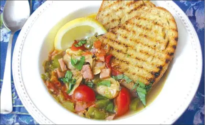  ?? Associated Press photo ?? This photo shows a clam, tomato and bacon stew with grilled garlic bread in New York