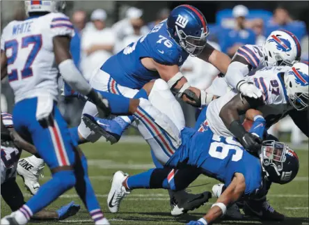  ?? ADAM HUNGER - THE ASSOCIATED PRESS ?? Buffalo Bills defense tackles New York Giants’ Saquon Barkley, bottom, during the second half of an NFL football game, Sunday, Sept. 15, 2019, in East Rutherford, N.J.