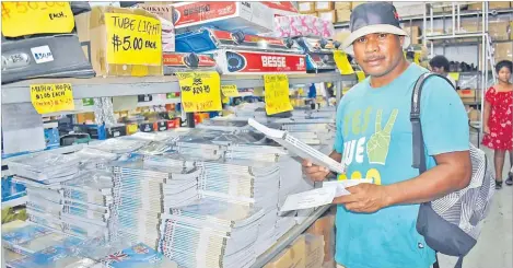  ?? Picture: SOPHIE RALULU ?? Luke Tavisa shops for his children’s school stationery in Suva last week.