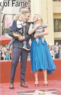  ??  ?? Reynolds (above and left) with his daughters James (left) and wife Lively pose on his star on the Hollywood Walk of Fame in Hollywood, California on Thursday. — Reuters photos