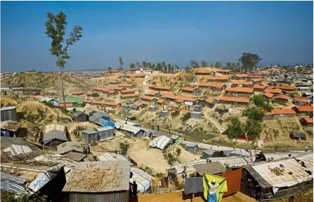  ?? — aP ?? Poor living arrangemen­ts: a rohingya refugee hanging a blanket out to dry at the Balukhali camp near Cox’s Bazar. the camps in this area have been reported to be overcrowde­d and unhygienic.