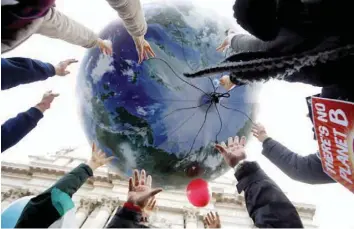  ?? — Reuters ?? Protesters throw up a globe-shaped balloon during a rally held the day before the start of the Paris World Climate Change Conference, known as the COP21 summit, in Rome, on November 29, 2015.