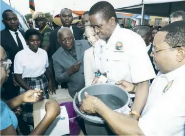  ??  ?? President Edgar Lungu with Water Developmen­t,Sanitation and Environmen­t Protection Permanent Secretary Dr.Edward Chomba demonstrat­e how to fetch water during the Handover of the Smart Water Supply Scheme in Lusaka yesterday