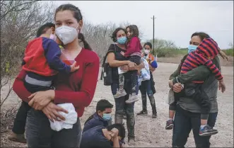  ?? ADREES LATIF / REUTERS ?? Asylum-seeking migrants from Central America await transport in La Joya, Texas, after crossing the Rio Grande by raft from Mexico on Sunday. Many children have come unaccompan­ied.