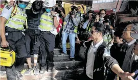  ?? Ng Han Guan / Associated Press ?? Polytechni­c University president Jin-Guang Teng watches a hurt protester in Hong Kong. The city has been roiled by protests against authoritar­ian action.