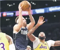  ?? — AFP photo ?? Doncic drives to the basket against Anthony Davis of the Los Angeles Lakers.
