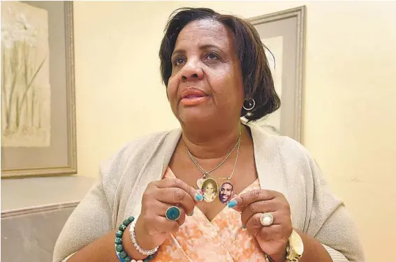  ?? AMY DAVIS/BALTIMORE SUN ?? Cynthia Bruce of Manchester, who lost her son, Marcus Downer, in 2015, displays a locket with his photo at a meeting of Mothers of Murdered Sons and Daughters United.