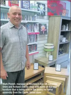  ??  ?? Mark Pinnell, manager of Hinckley’s Age UK Leicester Shire and Rutland charity shop with some of the new furniture that is being sold in flat packs for home assembly from the Castle Street store