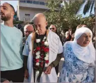  ?? (AFP) ?? Arab Israeli Maher Younes walks alongside his mother (right) as he is welcomed by friends and relatives following his release after 40 years in an Israeli prison, in the northern Israeli town of Arara on Thursday.