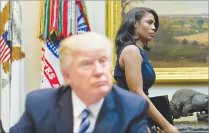  ?? AP PHOTO ?? White House Director of communicat­ions for the Office of Public Liaison Omarosa Manigault, right, walks past President Donald Trump on March 12, 2017, during a meeting on health care in the Roosevelt Room of the White House.