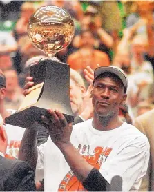  ?? JACK SMITH/ASSOCIATED PRESS FILE ?? Michael Jordan holds up the NBA Finals series MVP trophy after the Chicago Bulls beat Utah 87-86 on June 14, 1998. It was Chicago’s sixth championsh­ip, and it was Jordan’s final game with the team.