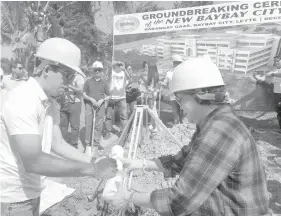  ??  ?? Baybay City Mayor Carmen L. Cari assists Leyte 5th district Rep. Jose Carlos Cari as he signs the time capsule containing the plans of Baybay's new city hall before it was lowered to the ground. Baybay City officials held the groundbrea­king ceremony...