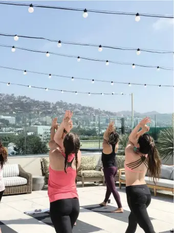  ??  ?? GUESTS take part in a yoga class at Kimpton La Peer in West Hollywood.|La Peer Hotel