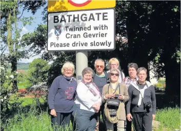  ??  ?? European visitors A group from Cran-Gevrier visit the twinning signpost in Bathgate.