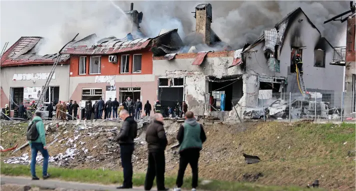  ?? ?? Non-military targets: Firefighte­rs battle a blaze after a civilian building in Lviv was hit by a Russian missile yesterday. Seven people were killed by air strikes in the city