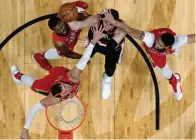  ?? Associated Press ?? ■ Portland Trail Blazers center Jusuf Nurkic shoots under pressure from New Orleans Pelicans' Anthony Davis, right, guard Ian Clark, top left, and Nikola Mirotic, bottom left, during the first half of Game 4 of a first-round NBA basketball playoff...