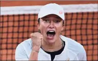  ?? MARTIN BUREAU / AFP via Getty Images ?? Poland’s Iga Swiatek celebrates after winning against Romania’s Simona Halep during their women’s singles fourth round tennis match on Sunday at the French Open in Paris.