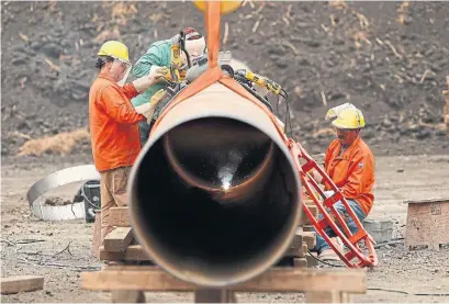  ?? JOHN WOODS THE CANADIAN PRESS ?? Enbridge workers weld pipe just west of Morden, Man. Enbridge said on Friday it would buy its U.S. master limited partnershi­p Spectra Energy Partners for a sweetened deal of $3.3 billion.