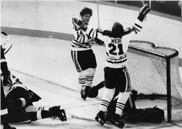  ??  ?? Stan Weir and Blair MacDonald celebrate after a goal on Rogie Vachon in the Edmonton Oilers’ first home game as a National Hockey League team on Oct. 13, 1979.