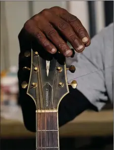  ?? (AP/Rogelio V. Solis) ?? Resting his hand against the head of his acoustic guitar, blues performer Jimmy “Duck” Holmes’ fingertips show the wear after years of performing without a pic.