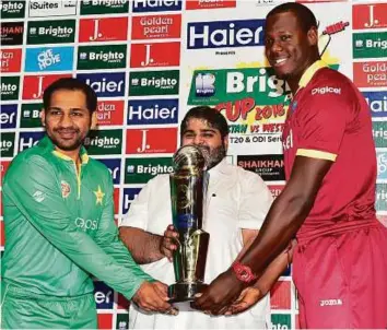  ?? Virendra Saklani/Gulf News ?? Pakistan T20 captain Sarfaraz Ahmad and his West Indian counterpar­t Carlos Brathwaite with Atif Riaz Sikka of sponsors Brighto Paints, ahead of the T20 series in Dubai