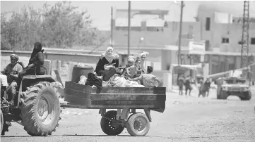  ??  ?? People are seen fleeing Raqqa, Syria. — Reuters photo