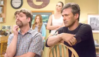  ?? | BOB MAHONEY/ TWENTIETH CENTURY FOX ?? Zach Galifianak­is and JonHamm( with Isla Fisher and Gal Gadot in the background) in a scene from “Keeping Up with the Joneses.”