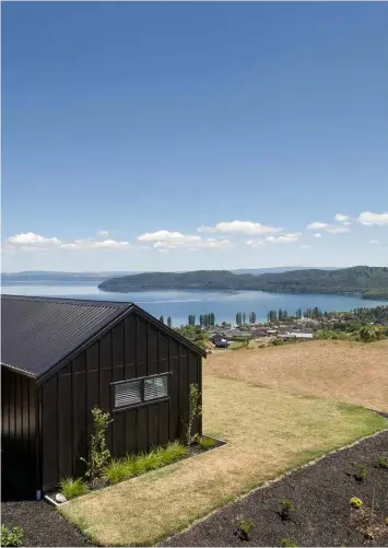  ??  ?? EXTERIOR The house is clad in HardieFlex, a tough material that was customised to resemble board-and-batten panelling. Painted black, the home makes a contempora­ry statement against the dramatic landscape of Lake Taupo.