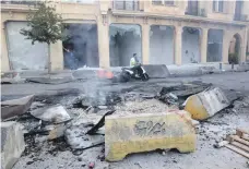  ?? Reuters; AFP ?? Top, a protest in the port city of Sidon. Demonstrat­ors have said they want to continue peacefully. Above, mopeds have been more suited than cars to dodging debris on the streets