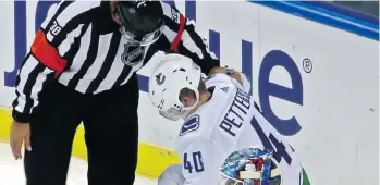  ?? SPORTSNET. ?? An NHL official checks on the status of Canucks rookie Elias Pettersson after he was tossed to the ice by Florida Panthers’ defenceman Mike Matheson on Saturday night. Pettersson was injured on the play.