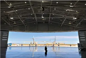  ?? AP Photo/Susan Montoya Bryan ?? ■ Virgin Galactic ground crew guide the company's carrier plane into the hangar Thursday at Spaceport America following a test flight over the desert near Upham, New Mexico.