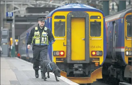  ??  ?? Constable Raymond Martin with Bruce a two year old rescue dog who is becoming a sniffer dog at Central Station in Glasgow.