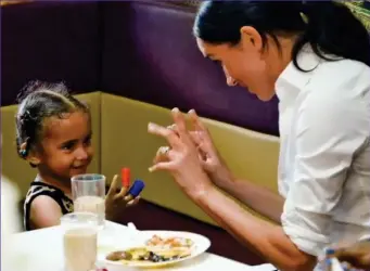  ??  ?? Making friends: Meghan with a little girl in the promotiona­l video for the book