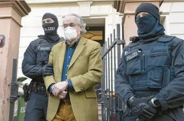  ?? BORIS ROESSLER/DPA ?? Police officers escort Prince Heinrich XIII of Reuss after his arrest Dec. 7 in Frankfurt, Germany.