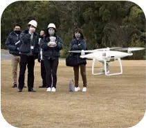  ??  ?? Kaizuka city employees learn to operate a drone for future use during disasters and other occasions last December.