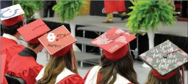  ??  ?? Various decoration­s adorned caps of graduating seniors, including an Indianapol­is Colts logo, a University of Oklahoma logo, a world map with the inscriptio­n “Let the journey begin,” and a floral pattern quoting Psalm 46:5, “God is within her, she will...