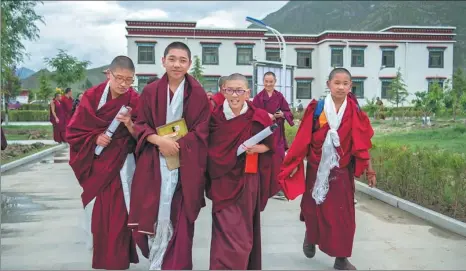  ?? HE PENGLEI / CHINA NEWS SERVICE ?? Young Living Buddhas walk on the campus of The Buddhist Academy of Tibet in Lhasa, Tibet autonomous region, after seven classmates graduated from their three-year tailor-made elementary school program.