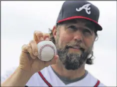  ?? CURTIS COMPTON / CCOMPTON@AJC.COM ?? New Braves pitcher R.A. Dickey shows off his knucklebal­l grip at Champion Stadium in Lake Buena Vista, Fla.