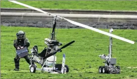  ?? ASSOCIATED PRESS ?? A member of a bomb squad checks a gyrocopter Wednesday after a man landed on the Capitol lawn in Washington. Lawmakers demanded explanatio­ns for how he managed to remain undetected as he flew the lightweigh­t craft to the National Mall.