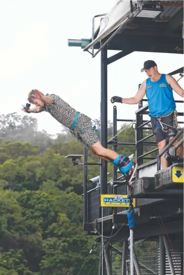  ?? Picture: BRENDAN RADKE ?? FLYING HIGH: Shae Littlewood, of Bungalow, launches off AJ Hackett's bungy tower with the help of jumpmaster Luke Major.