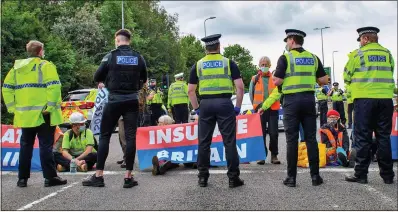  ?? ?? TAKING SIDES: Officers talk to protesters from Insulate Britain blocking a roundabout at Junction 20 of the M25